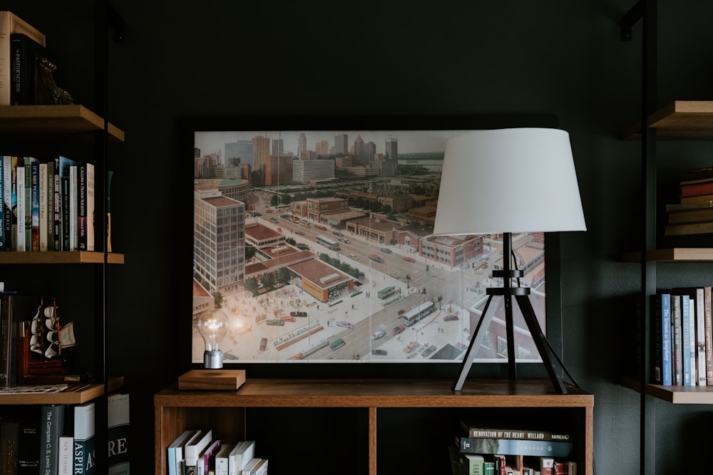 a lamp on a table in front of a picture of a city