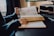 A person reading a book with notes and a laptop on a desk.