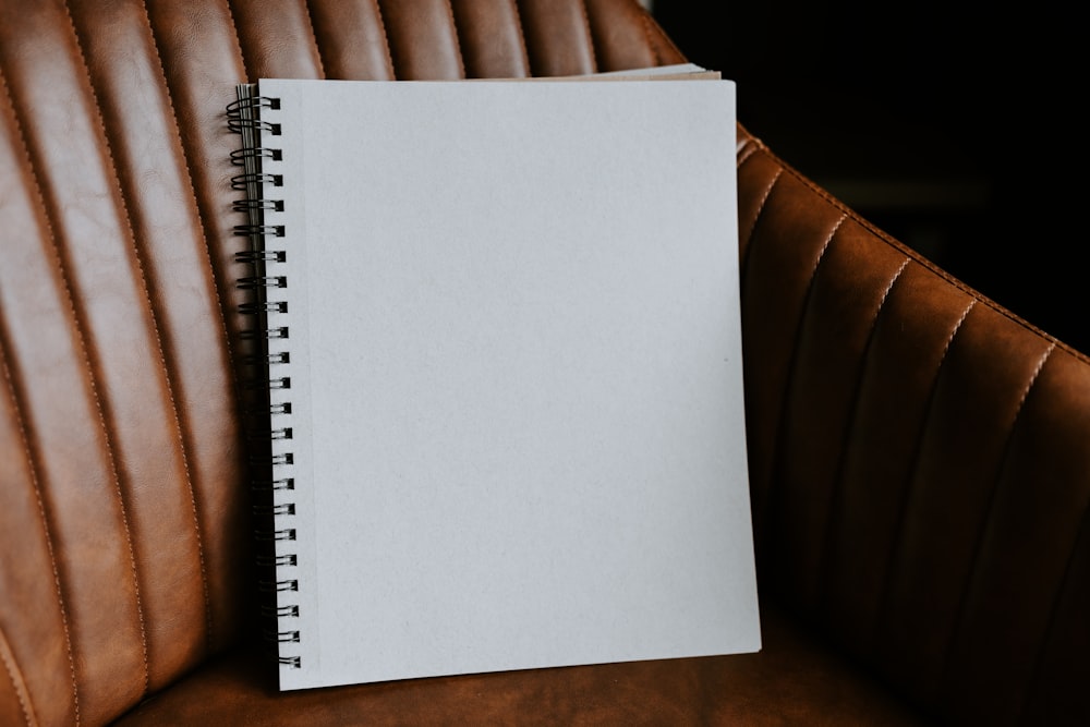 a notebook sitting on top of a brown leather chair