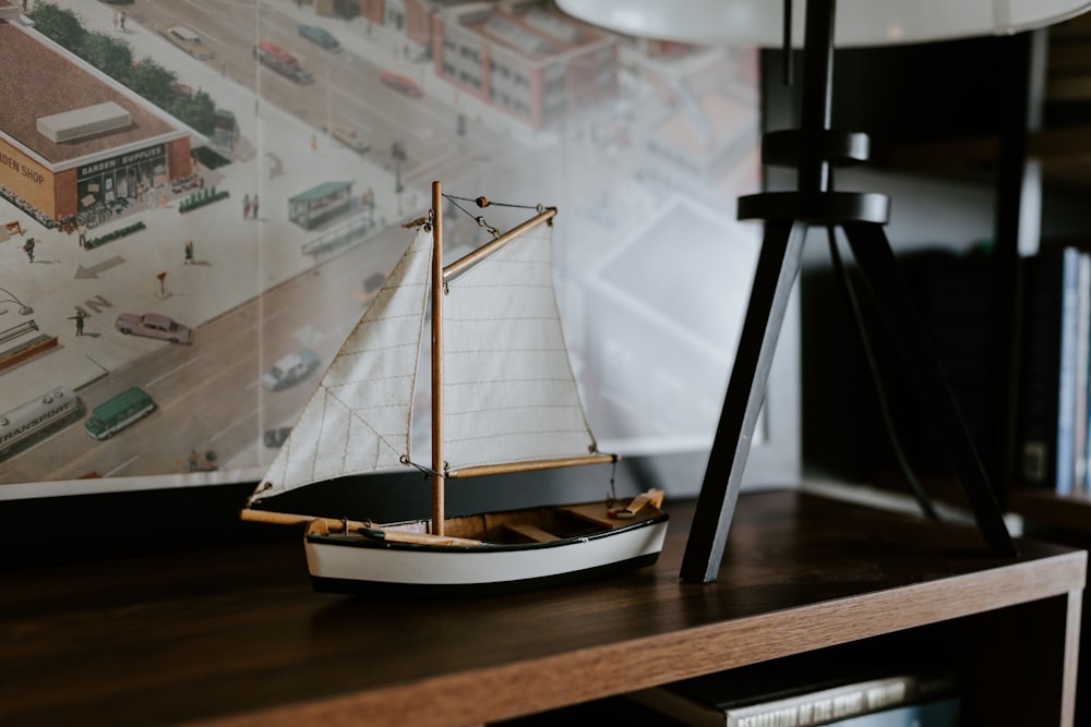 a model sailboat sitting on top of a wooden table