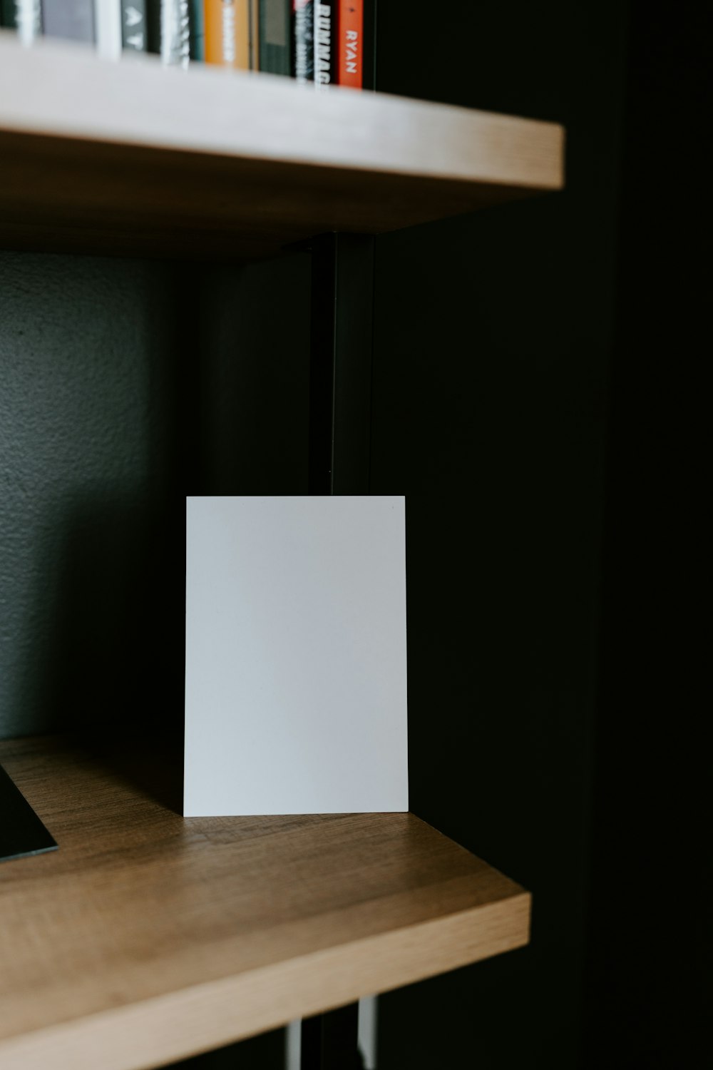 um cartão em branco sentado em cima de uma prateleira de madeira
