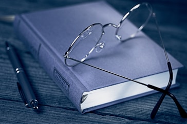 a pair of glasses sitting on top of a book