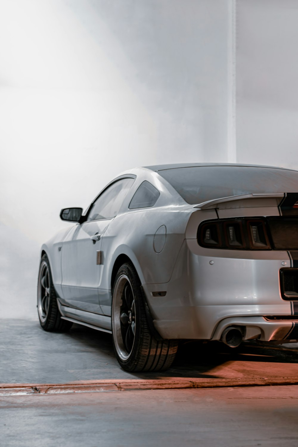 a white mustang car parked in a garage