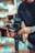 A person adjusts a professional camera mounted on a stabilizer, with focus on technical equipment in a setting that appears to be a studio or workspace. The scene conveys a sense of precision and craftsmanship.