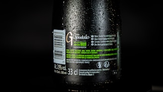 Close-up of a cold, amber beer bottle with dew drops, labeled brewnest, against a rustic background.