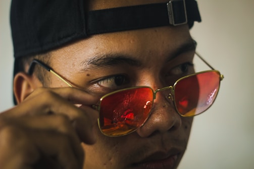 A close-up of a hand adjusting lenses on a pair of sleek, minimalist glasses.