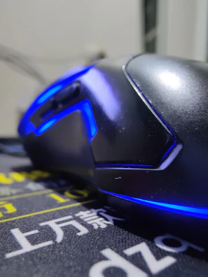 Close-up of a sleek wireless gaming mouse with glowing blue accents on a dark desk.
