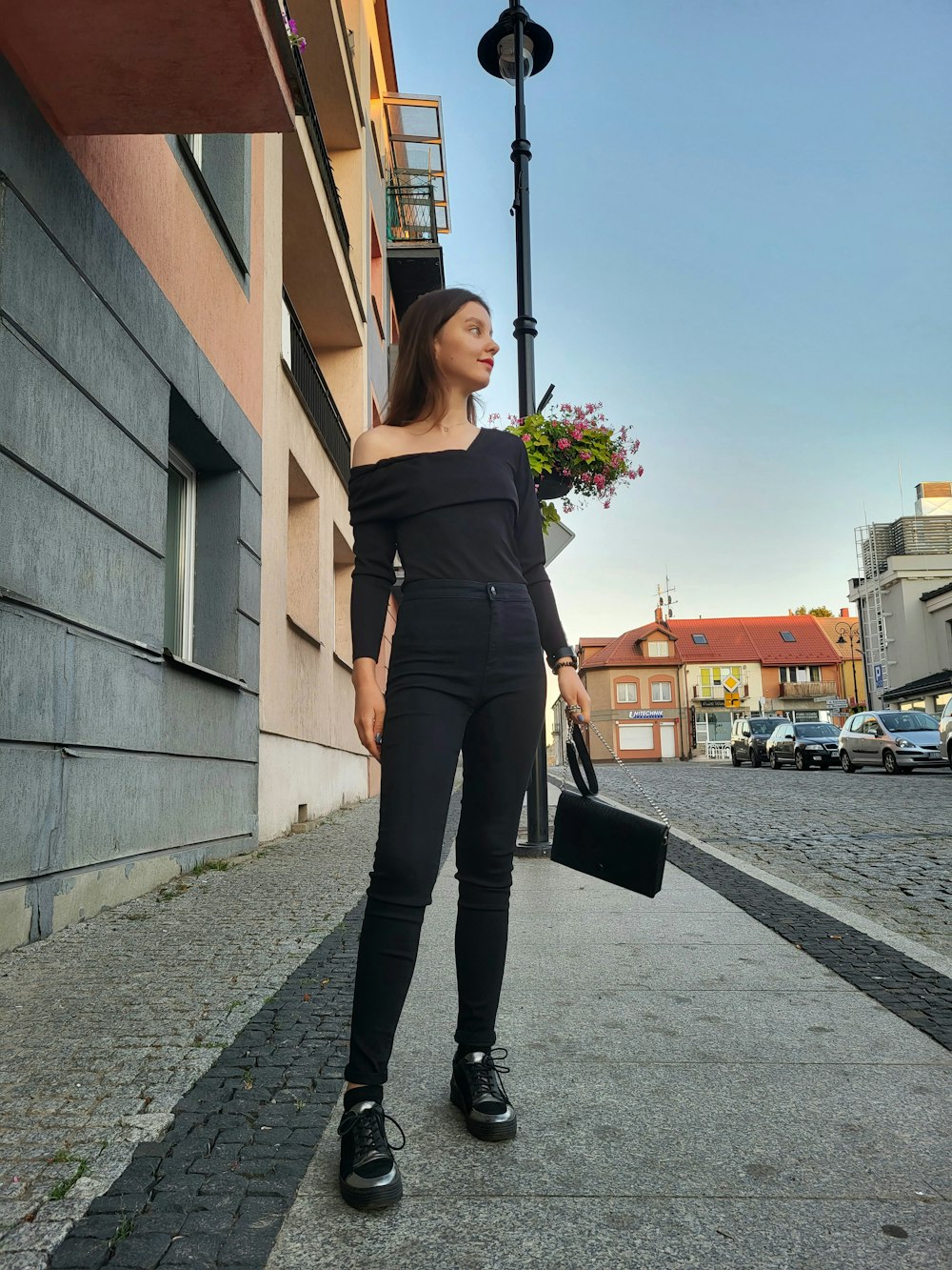 a woman in black is walking down the street