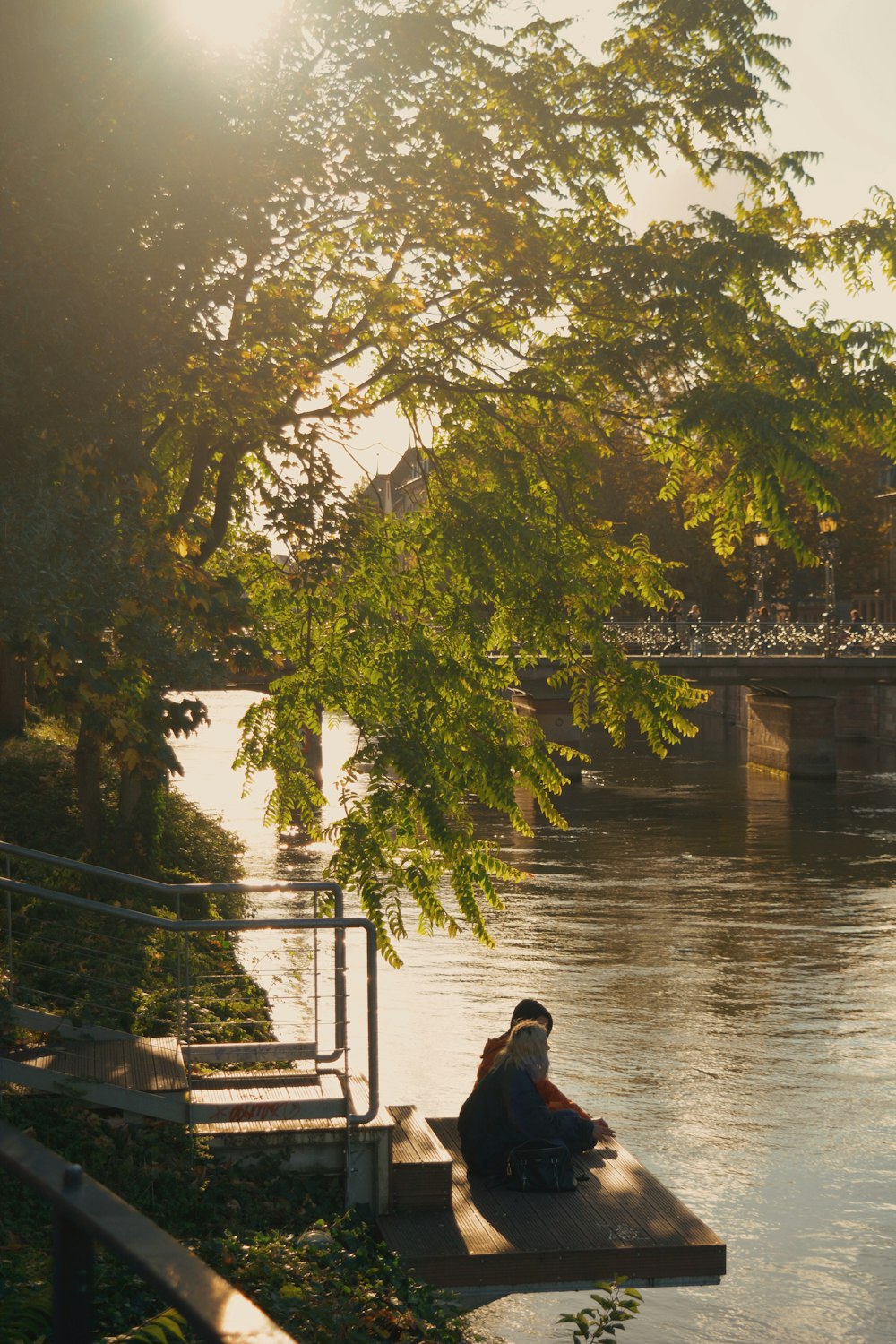 a person sitting on a dock near a body of water