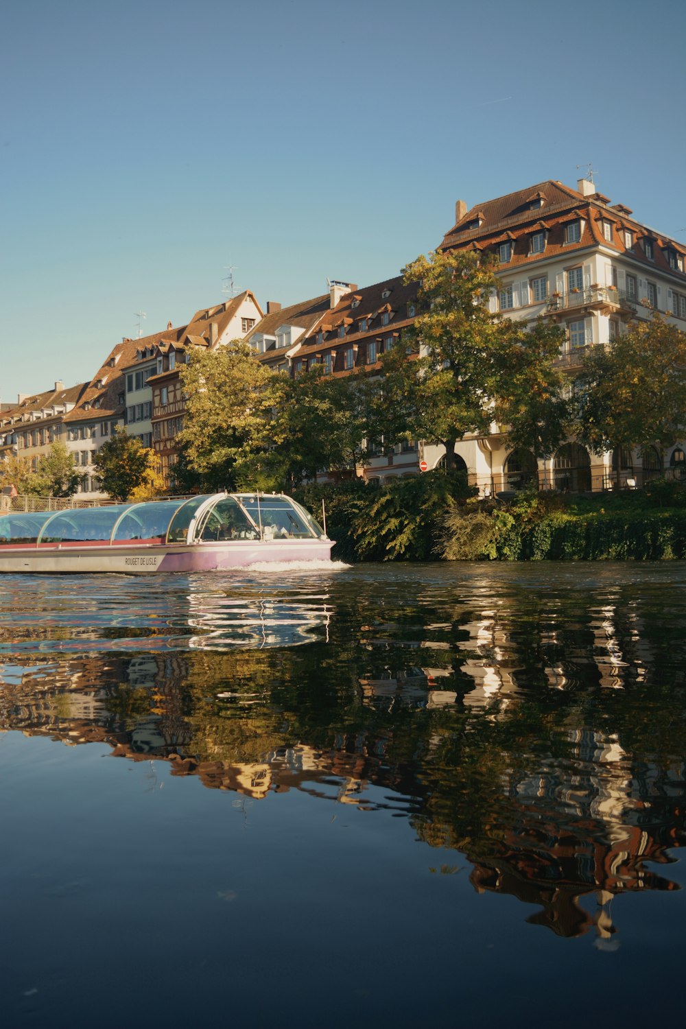 a boat on the water in front of a row of houses