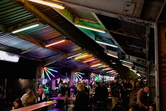 An evening market bustling with vendors and locals under strings of warm lights.