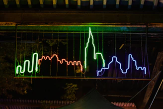 A glowing neon sign of the eternal vibe chronicles logo illuminating a nighttime cityscape.