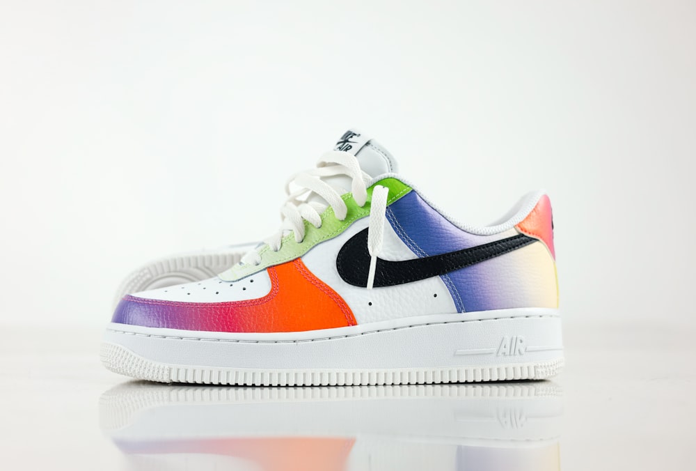 a colorful nike air force is on a reflective surface