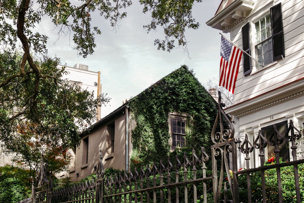 a house covered in ivy with an american flag on top of it
