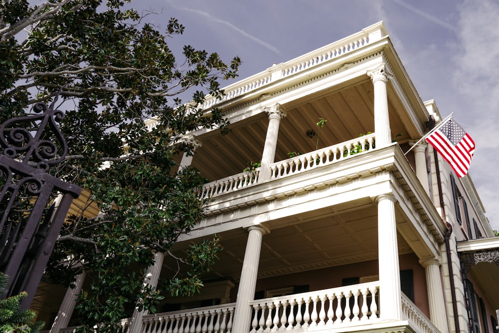 a large white house with an american flag on the balcony