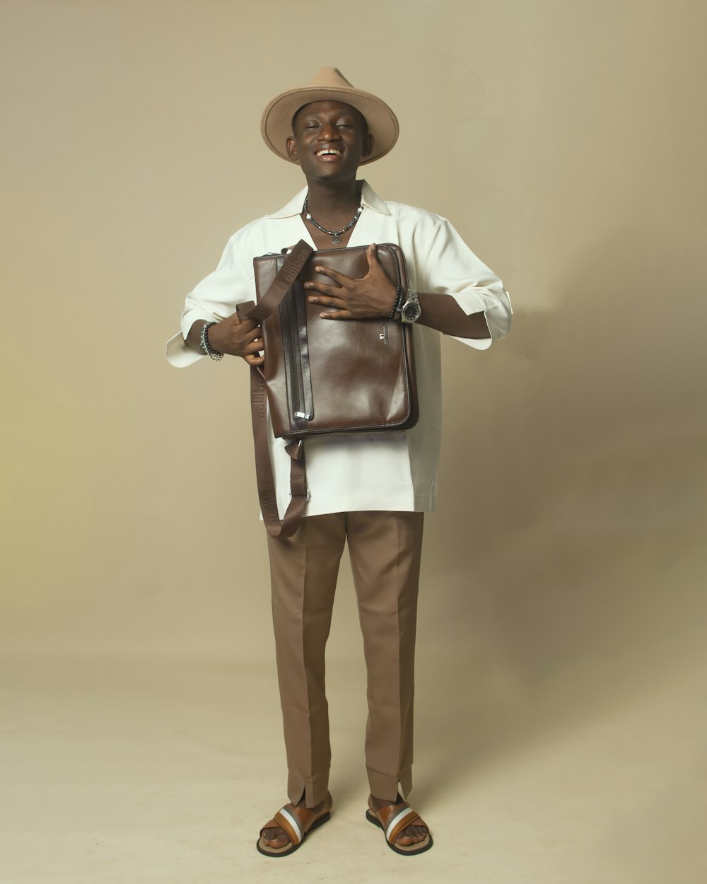a man wearing a hat and holding a brown bag