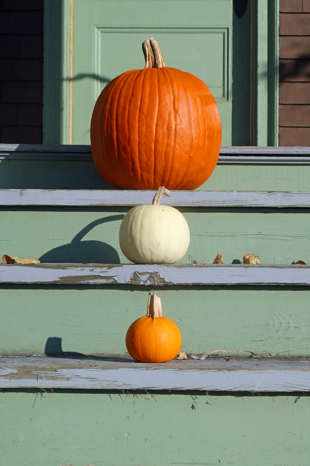 two pumpkins sitting on the steps of a house