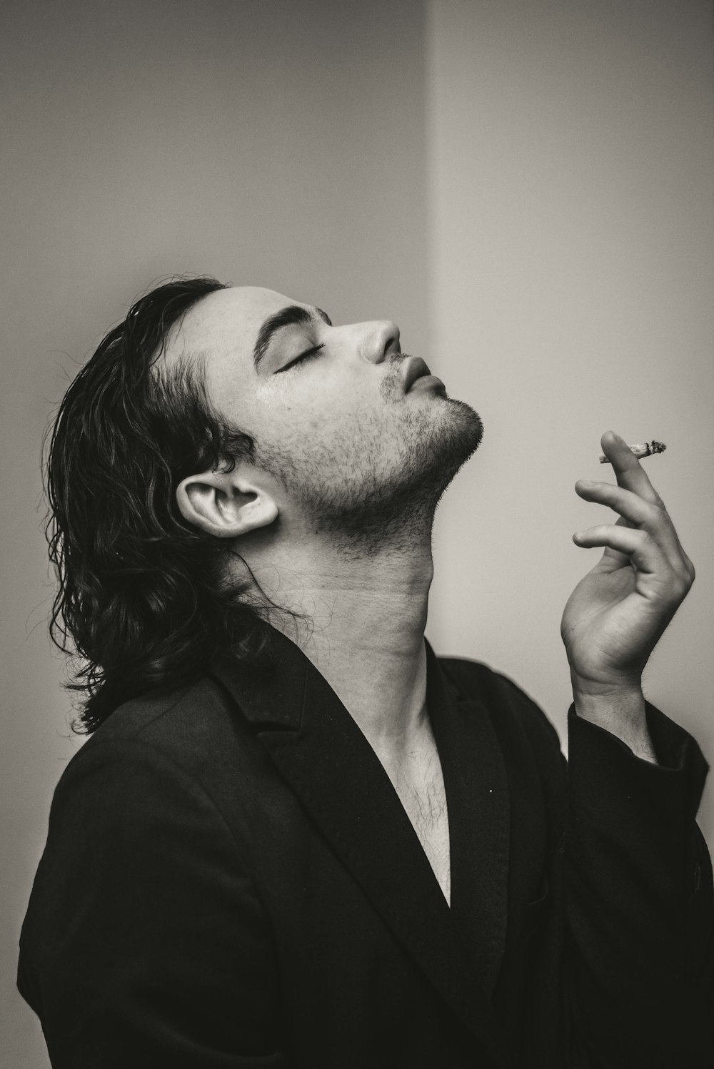 a man with long hair smoking a cigarette