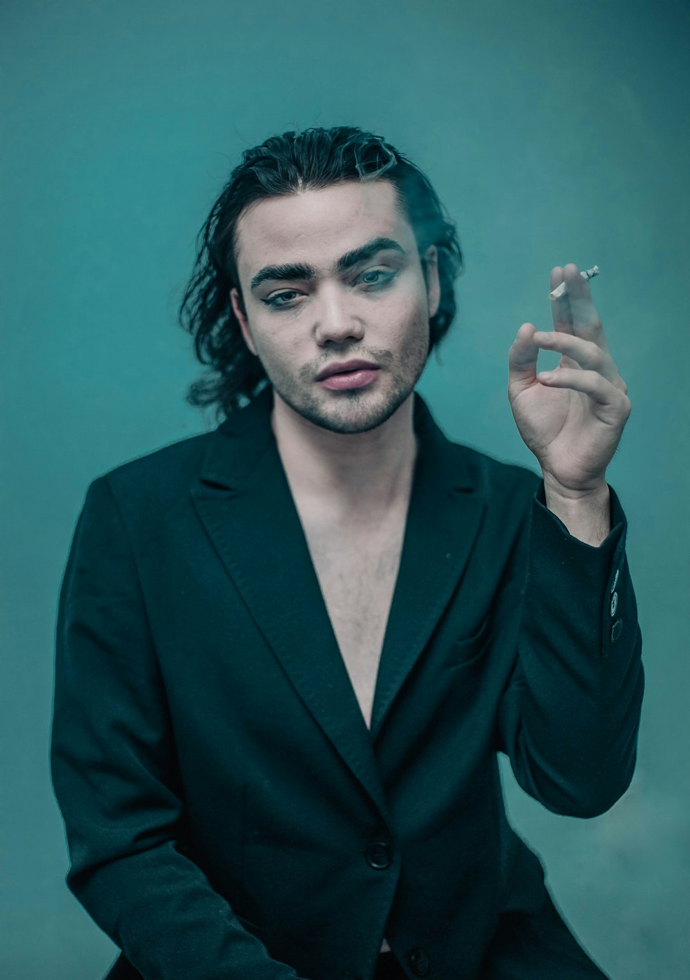 a man in a suit smoking a cigarette