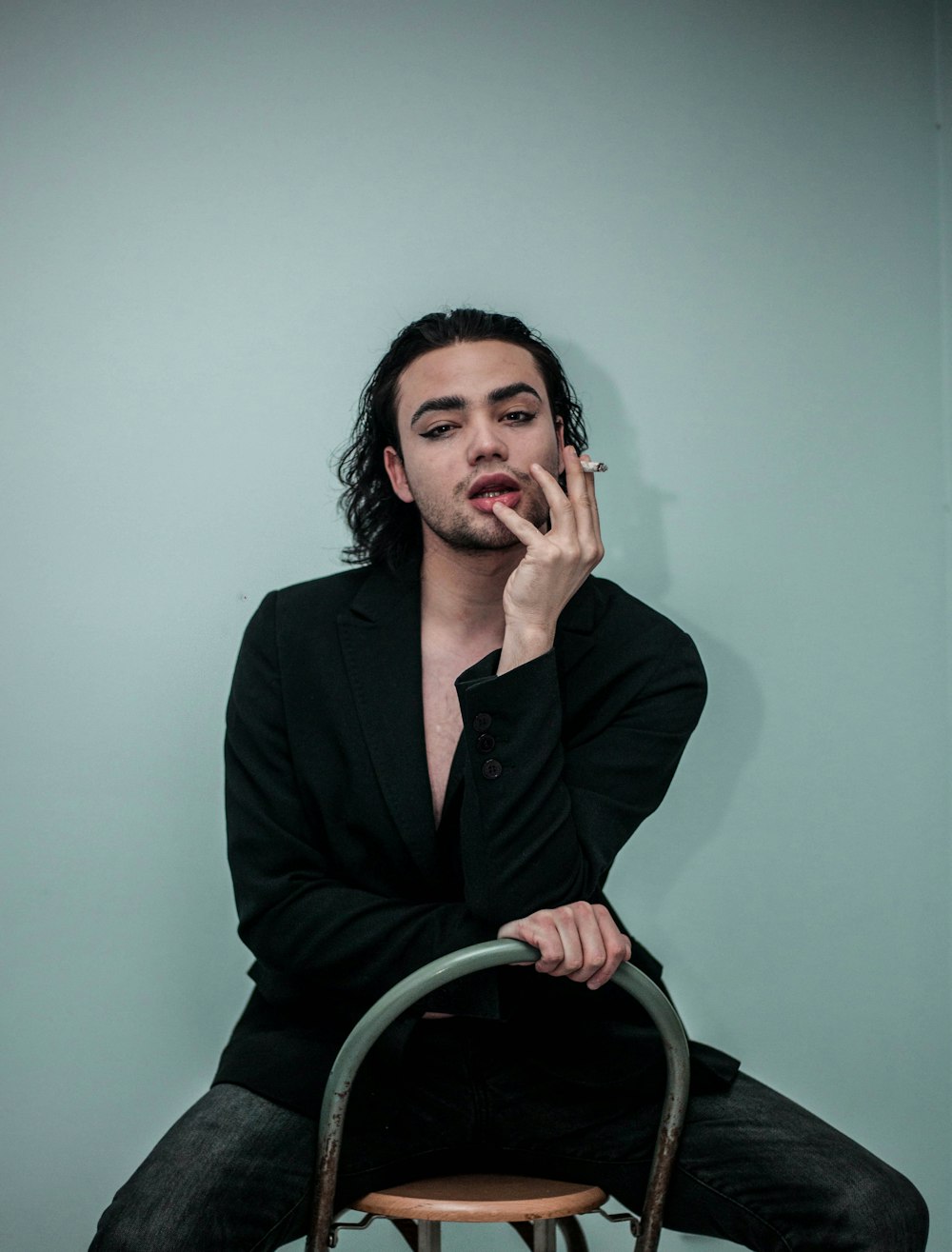 a man sitting on a chair smoking a cigarette