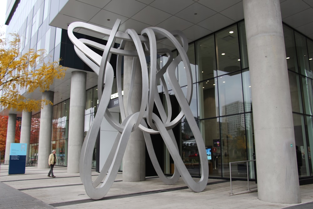 a large metal sculpture sitting in front of a building