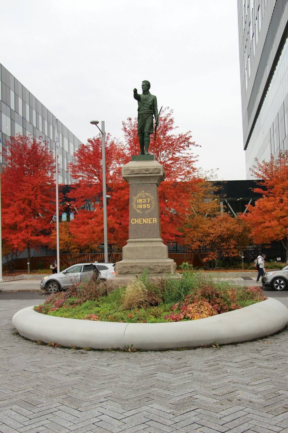 a statue of a man with a gun in a circle of flowers