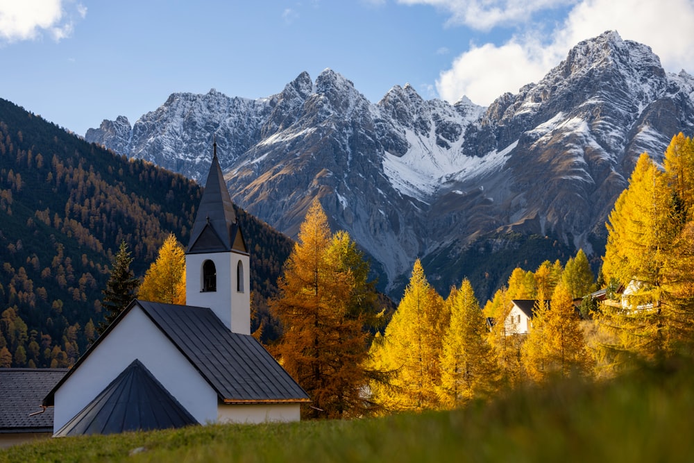 a church with a steeple in front of a mountain range