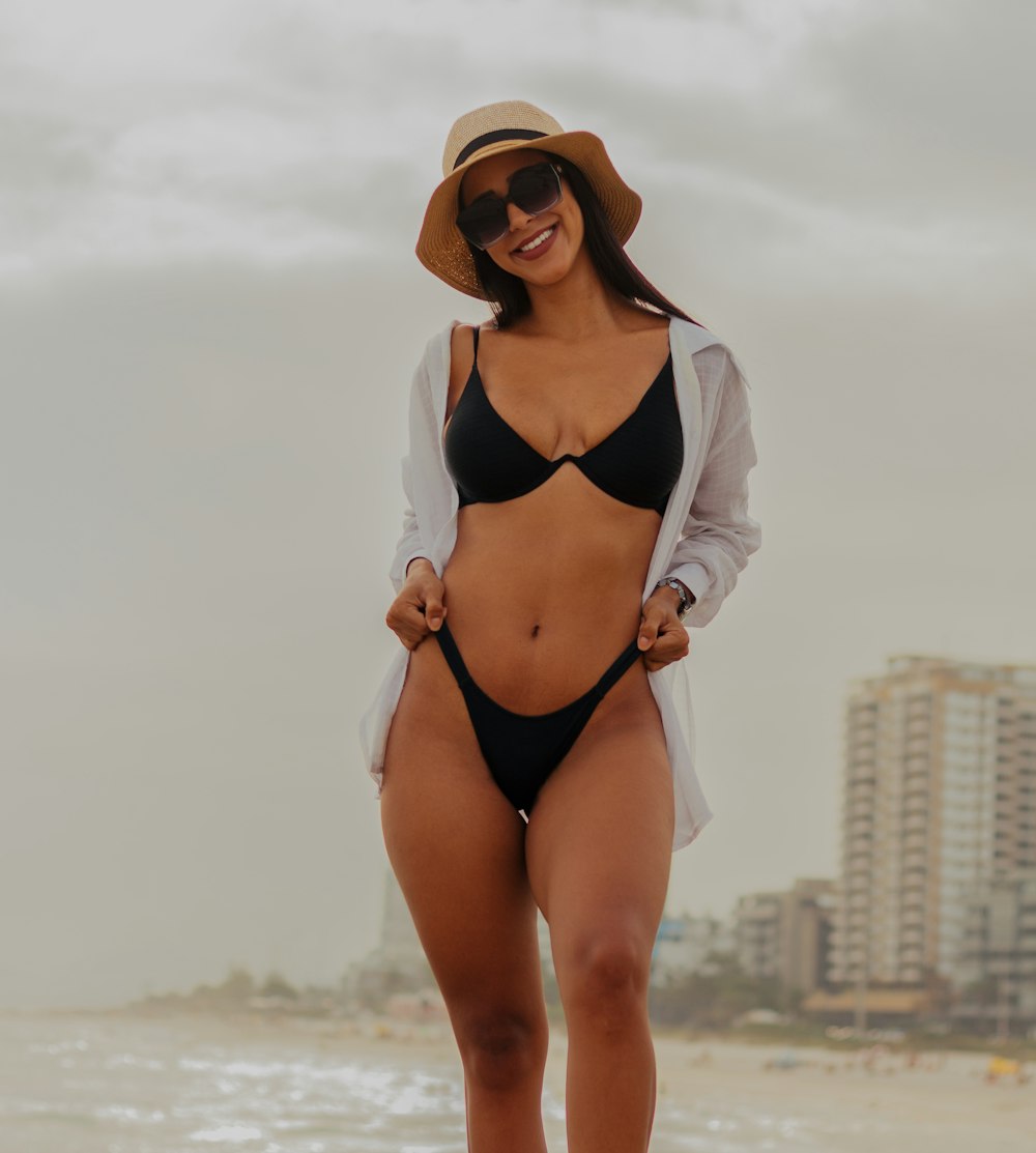 a woman in a bikini standing on the beach