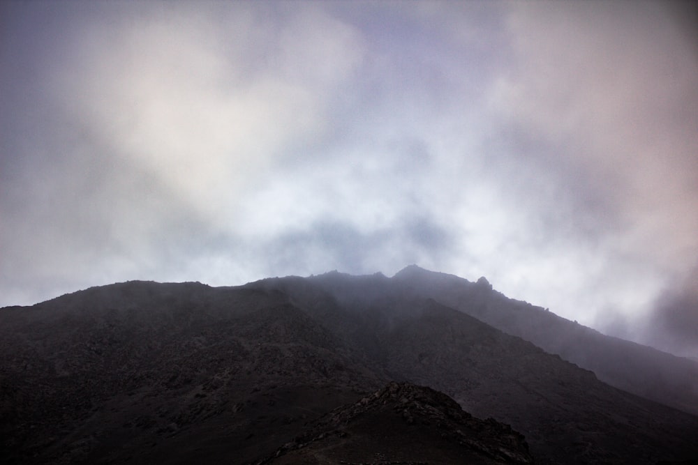 uma vista de uma montanha com nuvens no céu