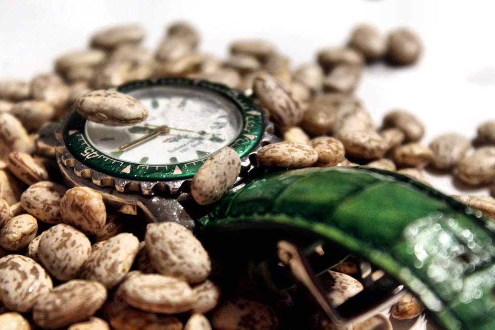 a watch sitting on top of a pile of peanuts