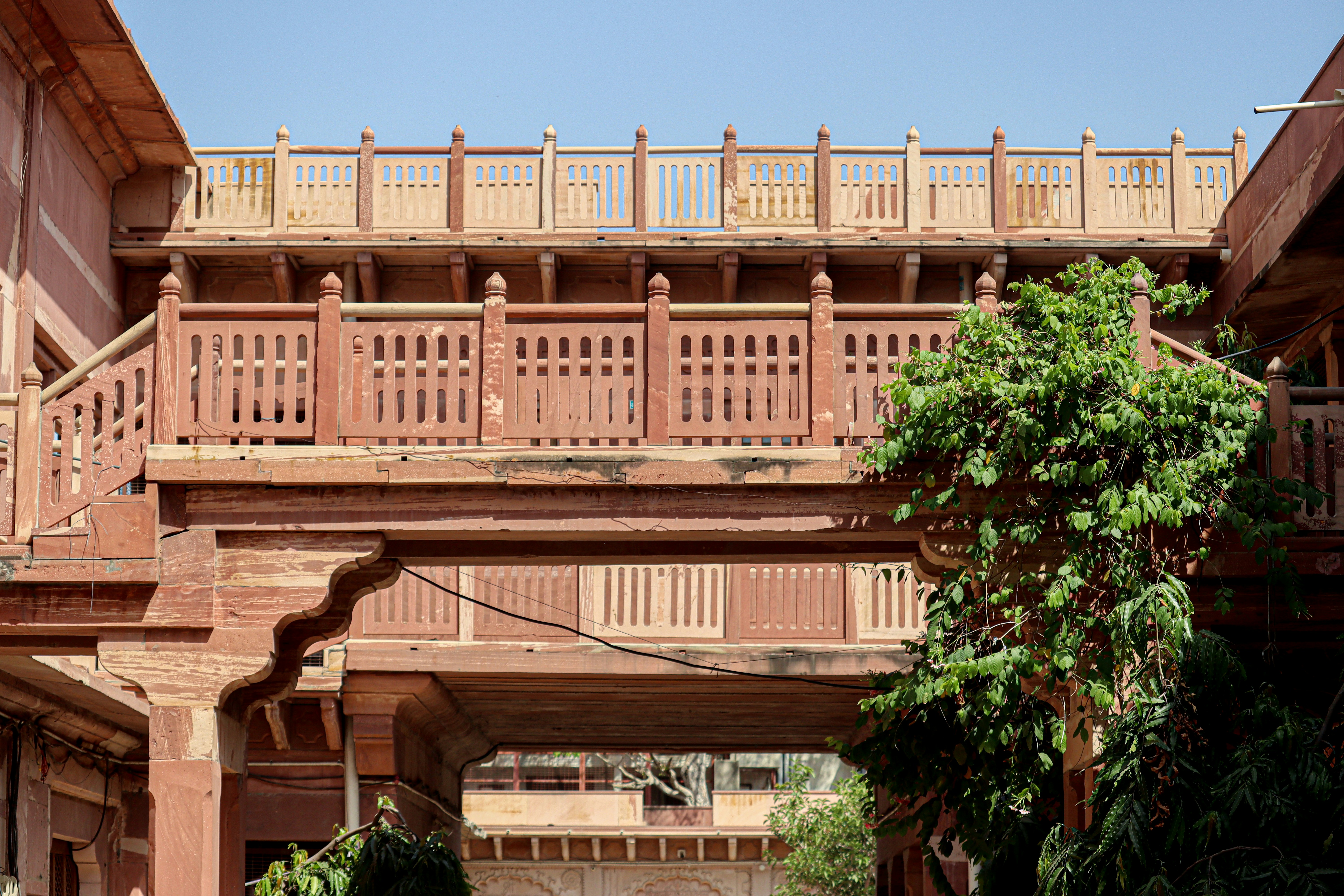 a building with a balcony and a tree in front of it