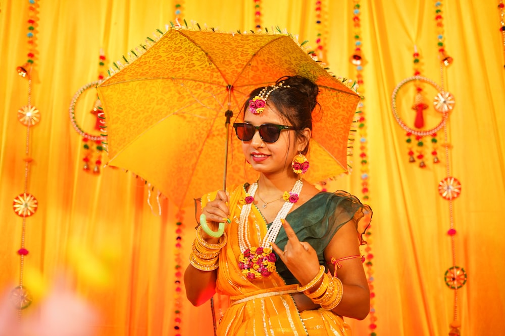 a woman in a yellow dress holding an umbrella