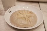 Close-up photo of a momo dumpling with a subtle mountain shape in the background.