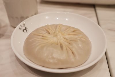 Close-up photo of a momo dumpling with a subtle mountain shape in the background.