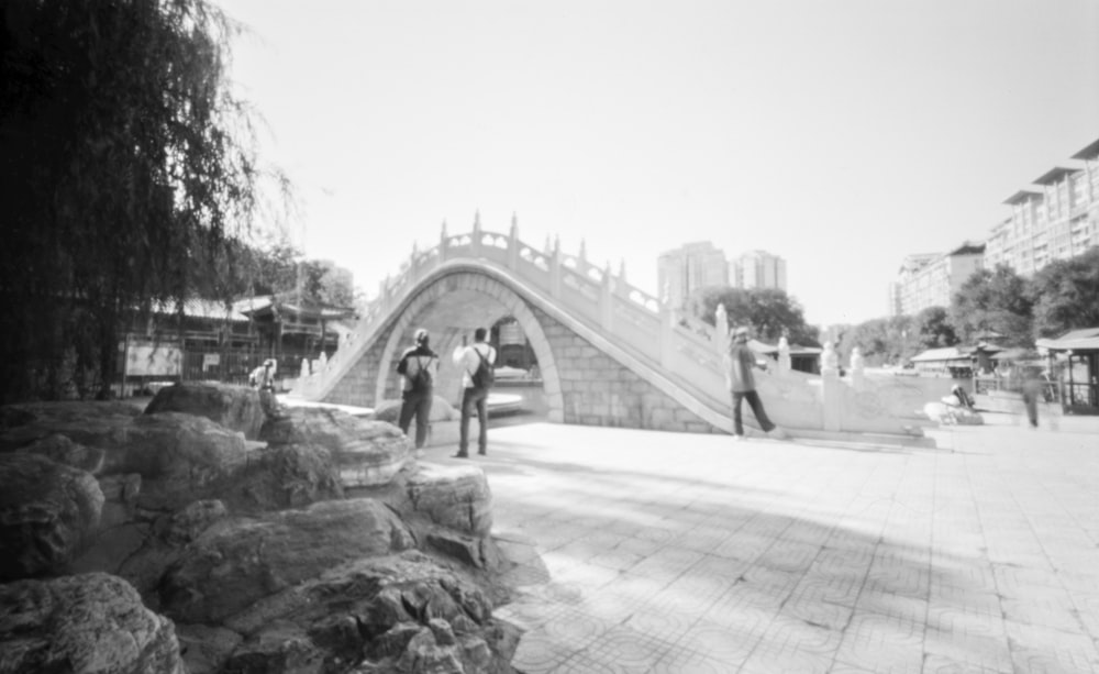 a black and white photo of people walking on a sidewalk