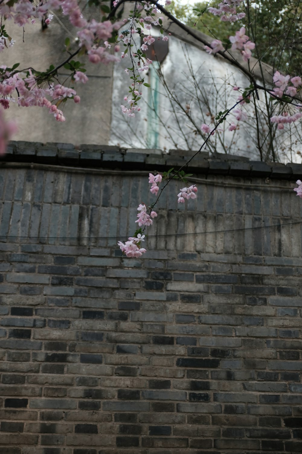 a brick wall with pink flowers on it