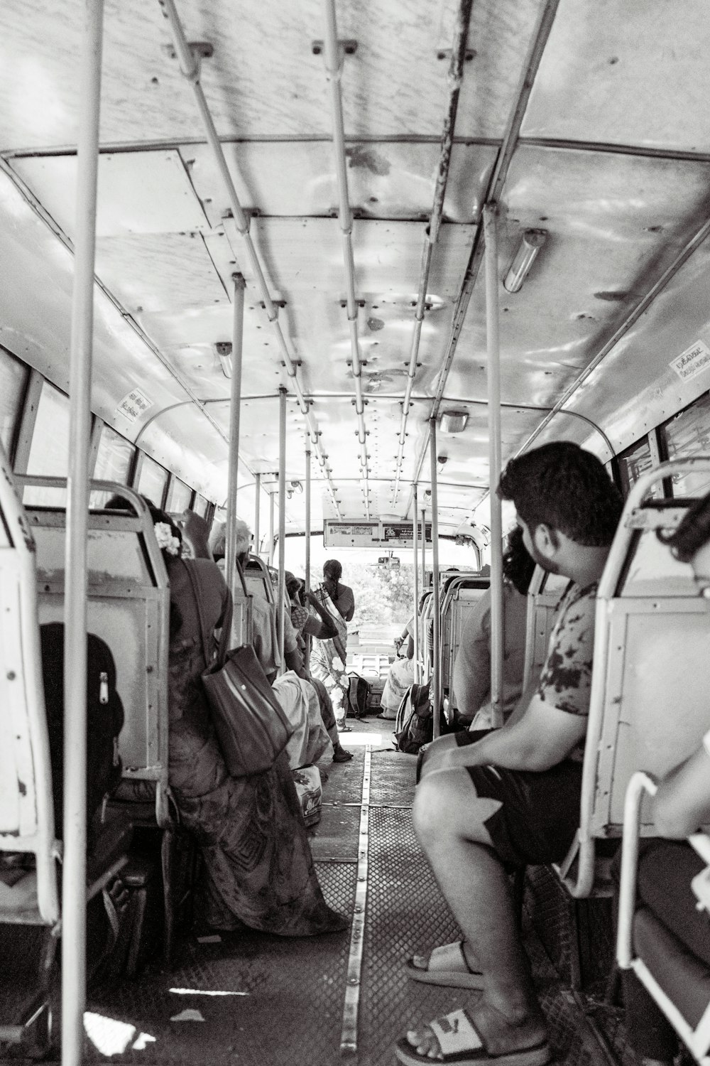 a black and white photo of people sitting on a bus