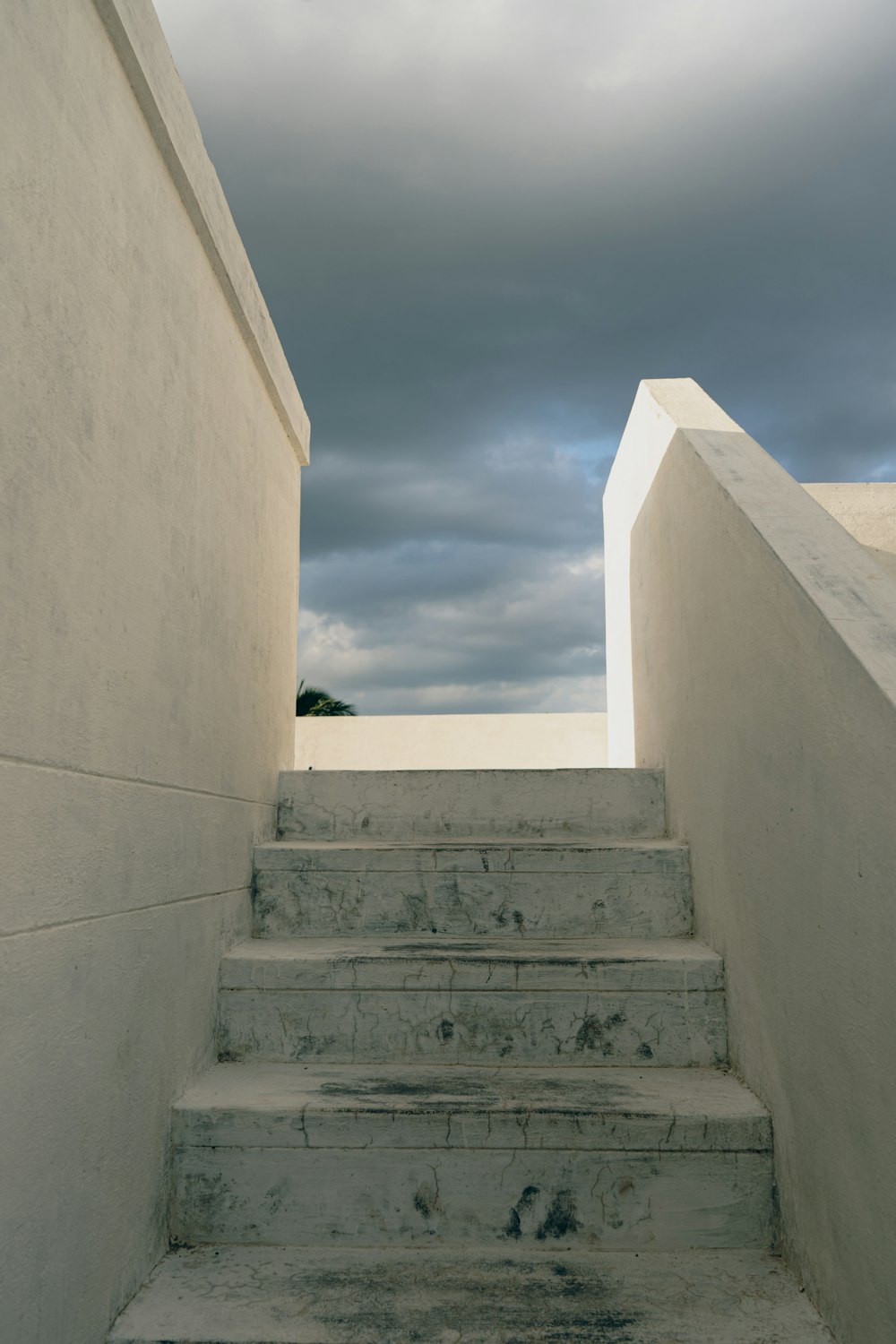 a set of stairs leading up to a cloudy sky
