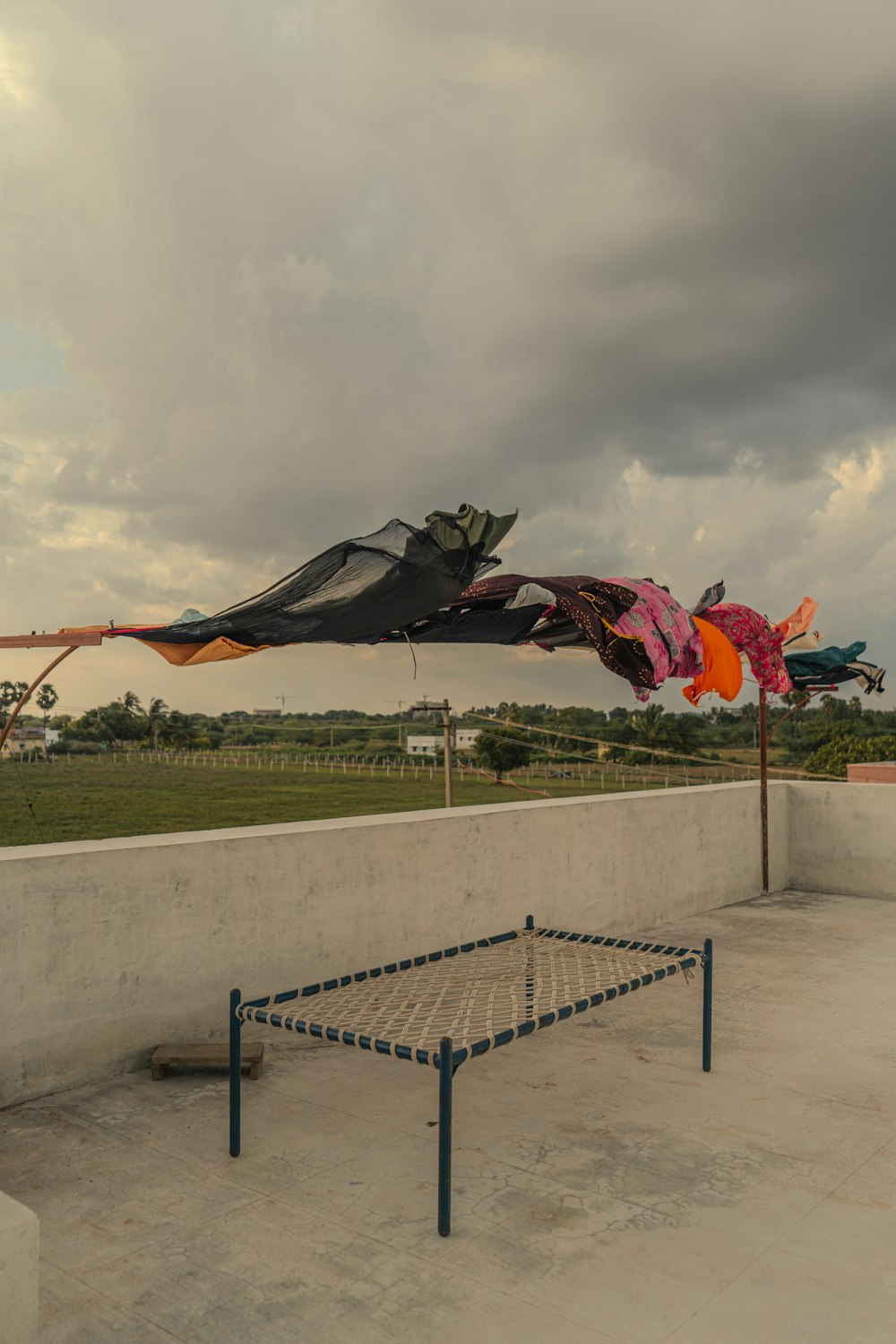 a kite is flying in the air over a bench