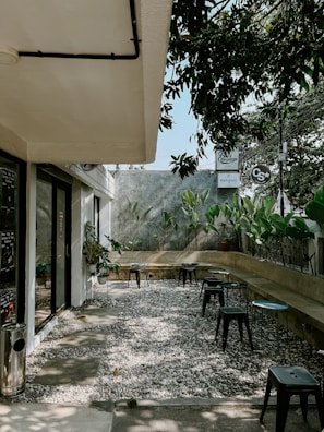 Outdoor seating area with small tables and green plants around Nieve Labs.