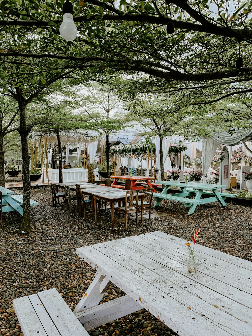 ein Picknickplatz mit Tischen, Bänken und Sonnenschirmen