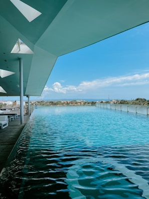 An outdoor infinity pool beside an opulent estate with sleek architectural lines.