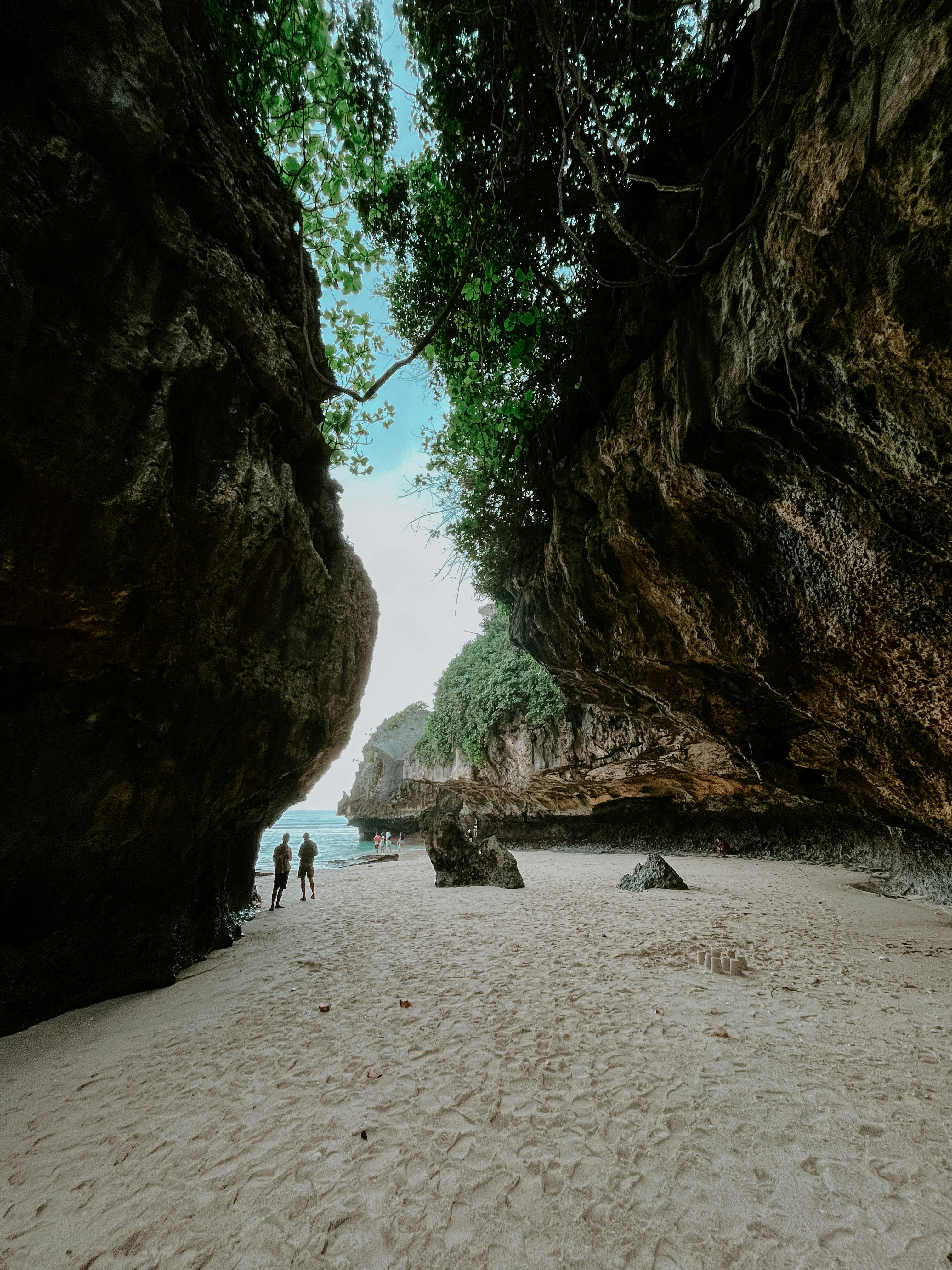 Beberapa orang berjalan di pantai berpasir
