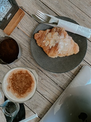 Close-up of a traditional Spanish breakfast with coffee and pastries on a wooden table.