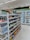 The image depicts the interior of a convenience store with neatly arranged shelves filled with various snacks, packaged foods, and beverages. There are several refrigerated sections visible in the background, stocked with drinks and dairy products. The store appears to be well-lit with a clean and organized layout.