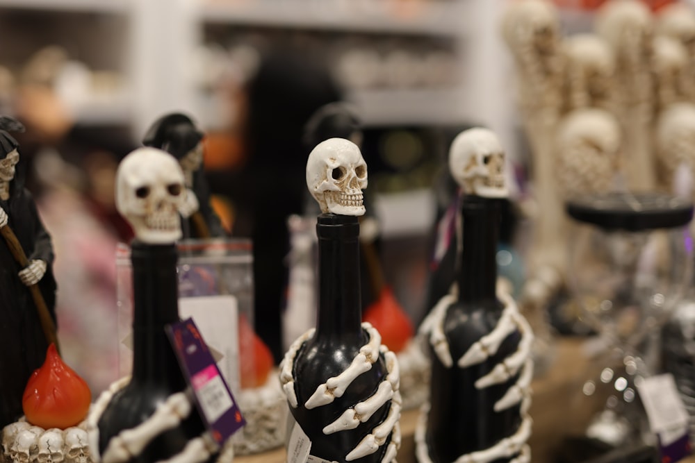 a table topped with bottles of wine and skeleton figurines
