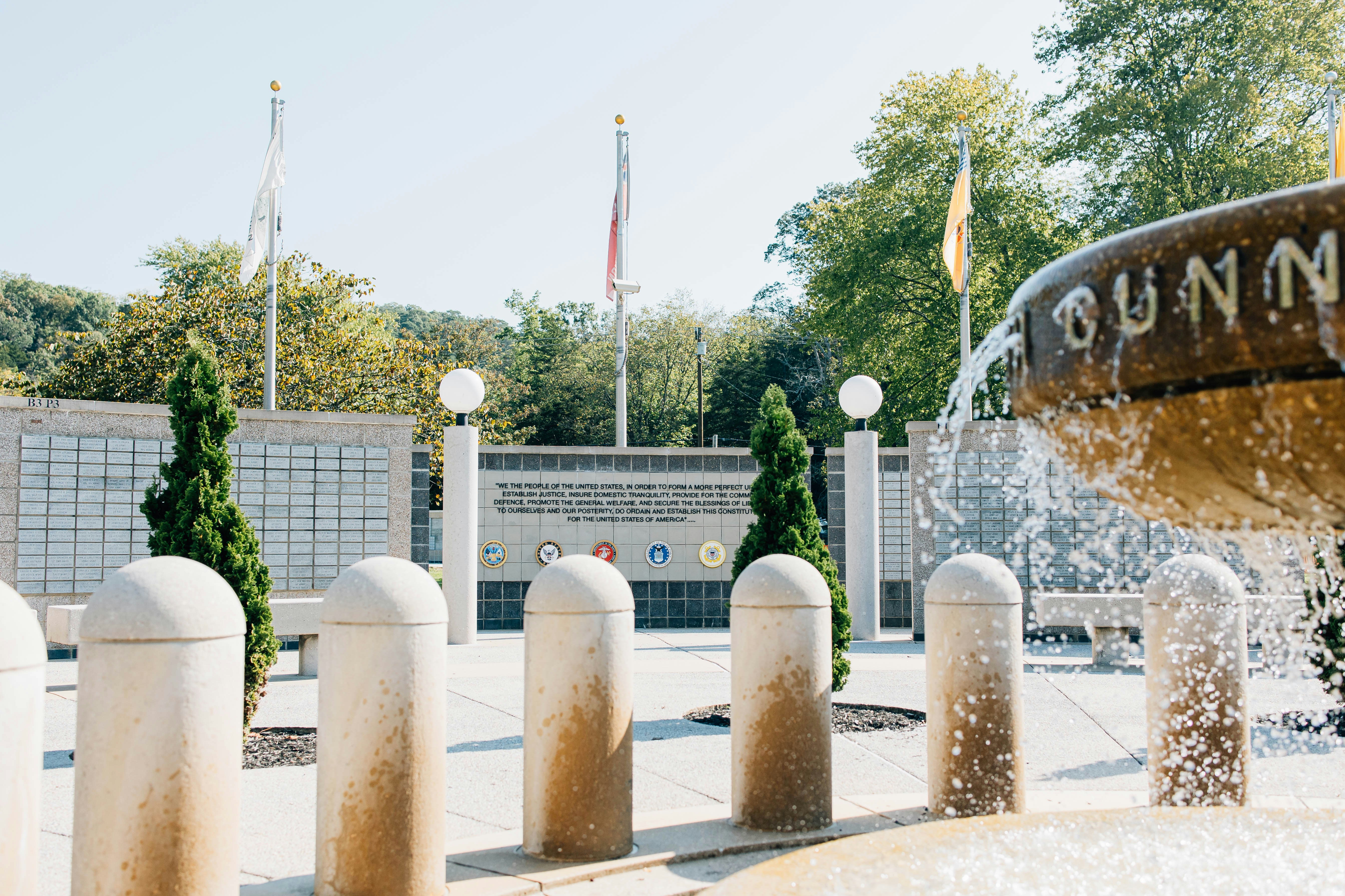 a fountain in front of a building with flags in the background, Veterans Memorial in Bella Vista, Arkansas