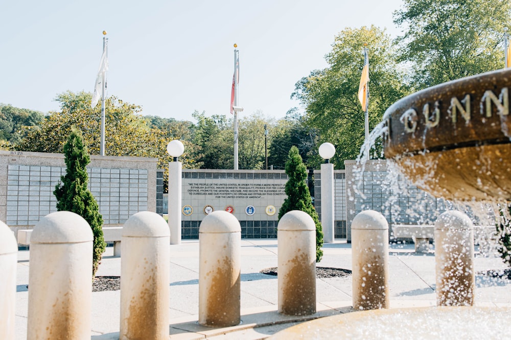 a fountain in front of a building with flags in the background