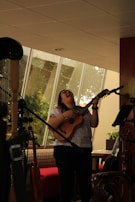 Close-up of hands playing vibrant blue ukulele with joyful expression.