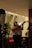 A cheerful person playing a ukulele in a cozy room filled with musical notes.